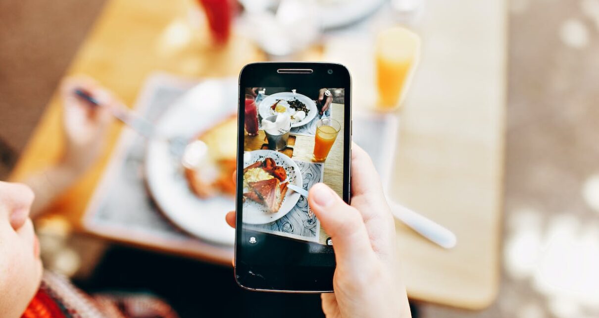 Person Holding Phone Taking Picture of Served Food from online food business
