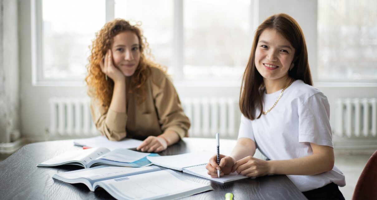 Two- girls -study- in- the- classroom -and -both- passing -Smile