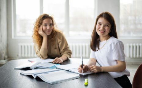 Two- girls -study- in- the- classroom -and -both- passing -Smile