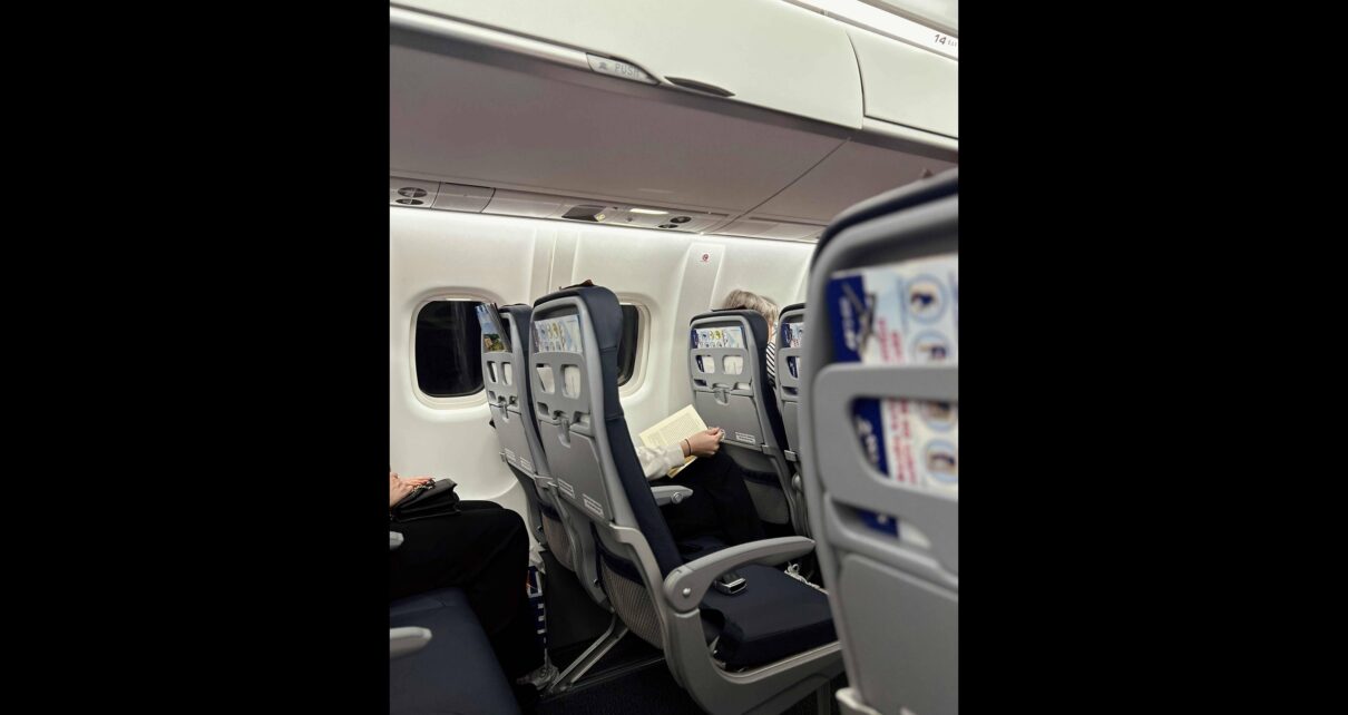 Interior view of a Brussels Airlines cabin showing passengers seated and reading during the flight.
