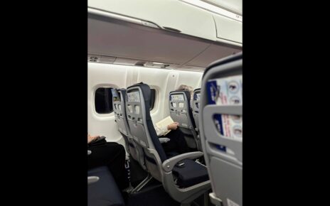 Interior view of a Brussels Airlines cabin showing passengers seated and reading during the flight.